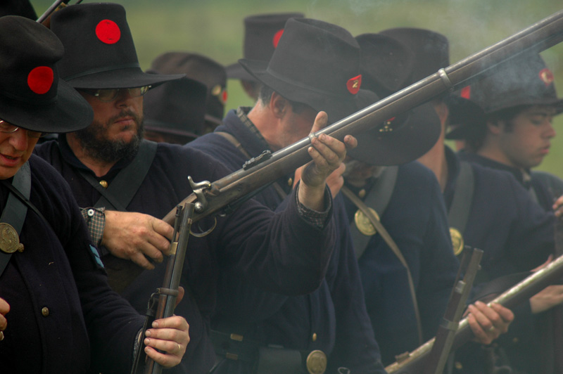 Volunarios del 24th de Masachusets  cargan y disparan sus armas durante una recreación.